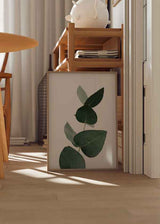 Cuadro con rama de eucalipto en tonos verdes oscuros sobre fondo claro. Disponible en kudeko.com.