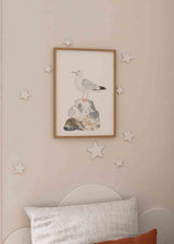 Wandbild mit weißer und grauer Möwe auf einem Felsen in Beige-, Blau- und Steintönen, im kindlichen Stil mit sanfter Komposition und neutralem Hintergrund. Erhältlich auf kudeko.com