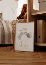 Quadro infantil com gaivota, gorro e cachecol em cinzento suave, corpo branco, asas azul acinzentado, bico amarelo e estilo delicado para quarto de bebé ou criança. Disponível em kudeko.com