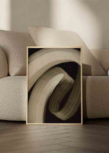 Cuadro con formas abstractas curvas en tonos beige, arena y marrón oscuro sobre fondo negro, composición envolvente de estilo abstracto. Disponible en kudeko.com