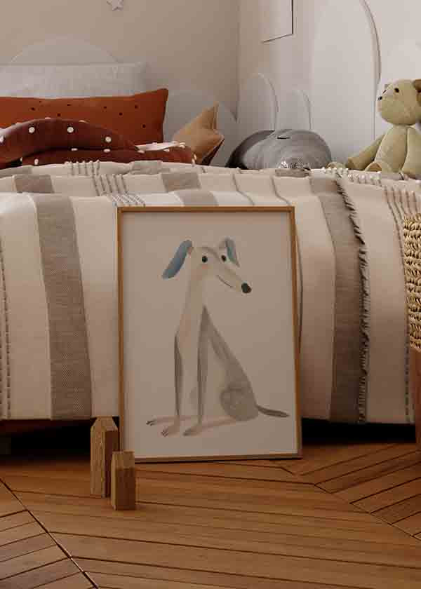 Wandbild mit sitzendem stilisiertem Hund, blauen Ohren, hellgrauem Körper, beigen Details, weißem Hintergrund und kindlichem Illustrationsstil. Erhältlich auf kudeko.com