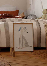 Wandbild mit sitzendem stilisiertem Hund, blauen Ohren, hellgrauem Körper, beigen Details, weißem Hintergrund und kindlichem Illustrationsstil. Erhältlich auf kudeko.com