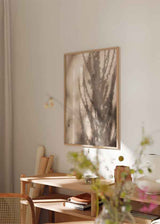 Cuadro con sombras de ramas proyectadas sobre pared con textura cálida. Disponible en kudeko.com.