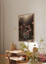 Cuadro minimalista de flores secas iluminadas por la luz del atardecer, ideal para decoraciones nórdicas. Disponible en kudeko.com.
