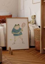 Wandbild mit Tennisfrosch, blau gepunktetem Shirt, weißer Hose, gelbem Ball, grünen Farbtönen und hellem Hintergrund im kindlichen Stil. Erhältlich auf kudeko.com