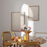 Quadro com linhas pretas fluidas sobre fundo bege claro, composição leve e orgânica, estilo minimalista e tons neutros para decoração de parede. Disponível em kudeko.com