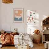 Quadro emoldurado com foguete espacial infantil de formas simples, fundo claro, pequenos pontos pretos, planetas discretos, tons vermelho tijolo, cinzento azulado e bege, estilo infantil nórdico. Disponível em kudeko.com