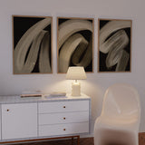 Tableau avec formes abstraites courbes en beige, crème et gris taupe sur fond noir, composition fluide au style abstrait pour une décoration murale contemporaine. Disponible sur kudeko.com
