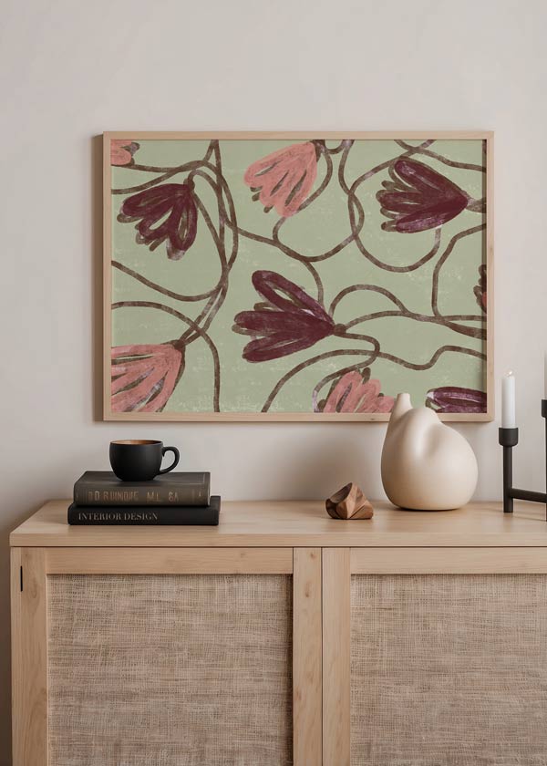 Cuadro horizontal con flores estilizadas en tonos rosa y granate, fondo verde claro, tallos ondulados marrones y composición orgánica de estilo floral. Disponible en kudeko.com