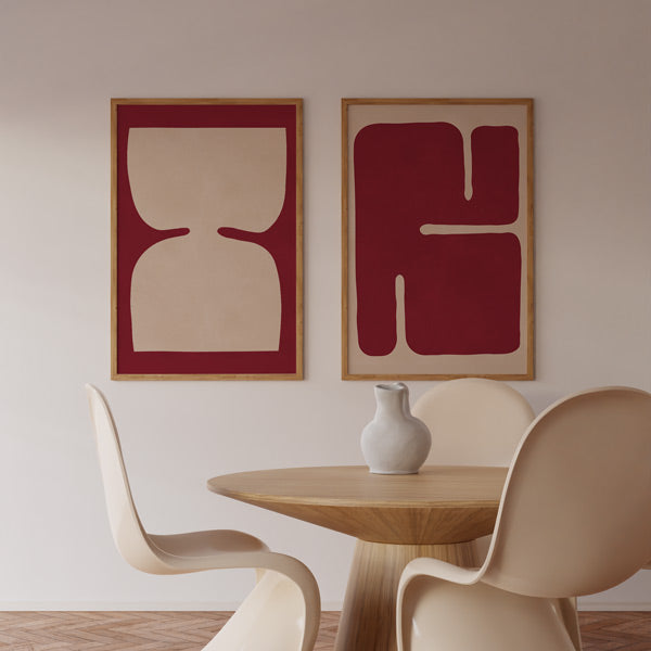 Ensemble de deux tableaux encadrés avec formes abstraites organiques rouge carmin, fond beige clair, bord sombre et style contemporain équilibré pour décoration murale. Disponible sur kudeko.com