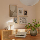 Set aus fünf Wandbildern mit Küstenkomposition in Sand, Creme, Taupe, Grau und Schwarz, mit abstrakten Formen, organischem Blatt, linearer botanischer Figur und fotografischem Motiv im Natur- und Landschaftsstil. Erhältlich auf kudeko.com