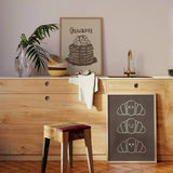 Cuadro cuadrado minimalista con adorables croissants felices. Disponible en kudeko.com