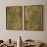Gerahmtes Wandbild mit abstrakter Komposition aus diffusen organischen Formen in Olivgrün, sanftem Beige und orangefarbenen Korallakzenten, im ruhigen zeitgenössischen Stil. Erhältlich auf kudeko.com