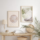 Conjunto de dos cuadros con formas abstractas, círculo texturizado, bloques orgánicos en beige, blanco, verde salvia, gris y finas líneas doradas, de estilo abstracto. Disponible en kudeko.com