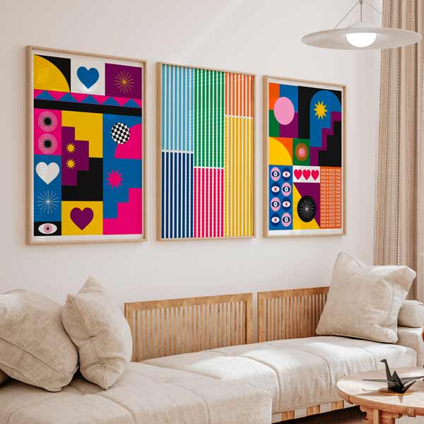 Conjunto de tres cuadros con formas geométricas, rayas multicolor, corazones, ojos y círculos en rosa fucsia, azul, amarillo, verde, naranja y negro, de estilo colorido. Disponible en kudeko.com