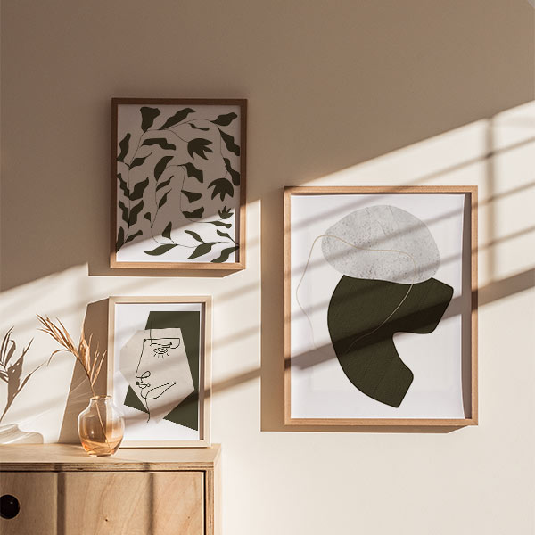 Set aus drei gerahmten Wandbildern mit organischen abstrakten Formen, linearem Gesicht und Blättern in Off-White, Schwarz und Taupe-Beige, im zeitgenössischen und reduzierten abstrakten Stil. Erhältlich auf kudeko.com