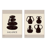 Ensemble de deux tableaux avec pierres empilées, vases noirs aux formes organiques, fond beige chaud et style minimaliste pour une décoration murale sobre. Disponible sur kudeko.com