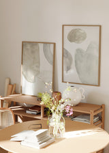 Set aus zwei Wandbildern mit organischen abstrakten Formen in Sandbeige, sanftem Grau und Weiß, klare Komposition im minimalistischen Stil für stilvolle Wandgestaltung. Erhältlich auf kudeko.com