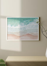 Cuadro horizontal con vista aérea de mar turquesa, espuma blanca y arena rosada, composición luminosa de estilo fotográfico inspirada en la costa. Disponible en kudeko.com