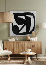 Quadratisches Wandbild mit schwarzen organischen Formen auf cremeweißem Hintergrund, abstrakte Komposition aus weichen Kurven und unregelmäßigen Flächen im zeitgenössischen Schwarz-Weiß-Stil. Erhältlich auf kudeko.com