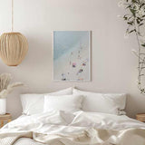 Quadro com vista aérea de praia com areia branca, água turquesa clara, banhistas dispersos, guarda-sóis em tons suaves e estilo fotográfico luminoso. Disponível em kudeko.com