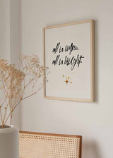 Cuadro con frase all is calm all is bright en caligrafía negra sobre fondo beige claro, con pequeñas estrellas doradas y estilo con frases. Disponible en kudeko.com