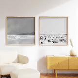 Cuadro cuadrado con escena de playa en blanco y negro, arena clara, horizonte difuso y pequeñas siluetas humanas dispersas, de estilo blanco y negro. Disponible en kudeko.com