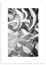 Cuadro de composición abstracta tipo graffiti sobre pared de bloques, con formas curvas en negro, blanco y gris, de estilo abstracto. Disponible en kudeko.com