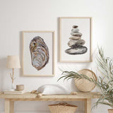 Cuadro de piedras apiladas en equilibrio, en tonos gris, beige, marrón y negro, con fondo blanco y estilo minimalista. Disponible en kudeko.com