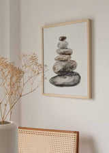 Cuadro de piedras apiladas en equilibrio, en tonos gris, beige, marrón y negro, con fondo blanco y estilo minimalista. Disponible en kudeko.com