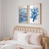 Quadro emoldurado com linhas onduladas em azul-marinho, azul médio e azul-claro sobre fundo branco, composição abstrata inspirada no movimento da água e num estilo marítimo sereno. Disponível em kudeko.com