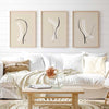 conjunto de tres cuadros minimalistas y abstratos con ilustraciones de trazos blancos y negros sobre un fondo beige crema. Ideal para ambientes modernos, salones y salas de estar - idea de decoración con cuadros