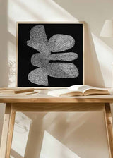 Quadro quadrado com formas orgânicas brancas, fundo preto, padrão gráfico repetitivo e composição abstrata em preto e branco de estilo contemporâneo. Disponível em kudeko.com