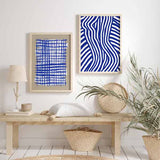 Gerahmtes Wandbild mit weiblicher Silhouette aus blauen und weißen Wellenlinien, starkem Kontrast, moderner grafischer Komposition und abstrakter zeitgenössischer Gestaltung. Erhältlich auf kudeko.com