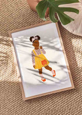 Cuadro con silueta de niña con falda amarilla, blusa rosa estampada, lazo en el cabello y bolso naranja, en tonos suaves y estilo infantil. Disponible en kudeko.com