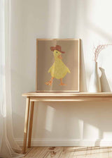 Cuadro de patito amarillo con sombrero vaquero marrón, pico naranja, fondo beige liso y estilo infantil de aire tierno y divertido. Disponible en kudeko.com