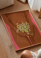 Tableau encadré avec figure féminine brune sur fond rose, bouquet de marguerites blanches aux cœurs jaunes, dans un style illustration contemporain. Disponible sur kudeko.com