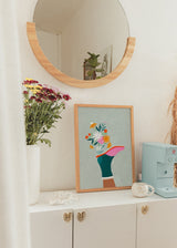 Quadro ilustrado colorido com perna e flores numa jarra, de Bea Muller. Disponível em kudeko.com