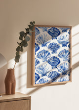 Gerahmtes Wandbild mit wiederholtem Muschelmotiv in Kobaltblau, Hellblau und Weiß, im küstennahen Illustrationsstil auf hellem Hintergrund. Erhältlich auf kudeko.com