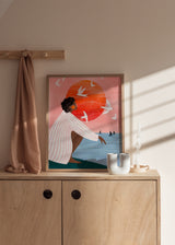 Cuadro decorativo de estilo mar_y_playa y ilustración colocado en salón, mujer contemplando el mar al atardecer, modelo Sunset On My Own