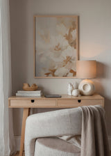 Quadro emoldurado de grandes flores em tons de creme, bege e caramelo claro, com composição suave, formas difusas e estilo floral etéreo e luminoso. Disponível em kudeko.com
