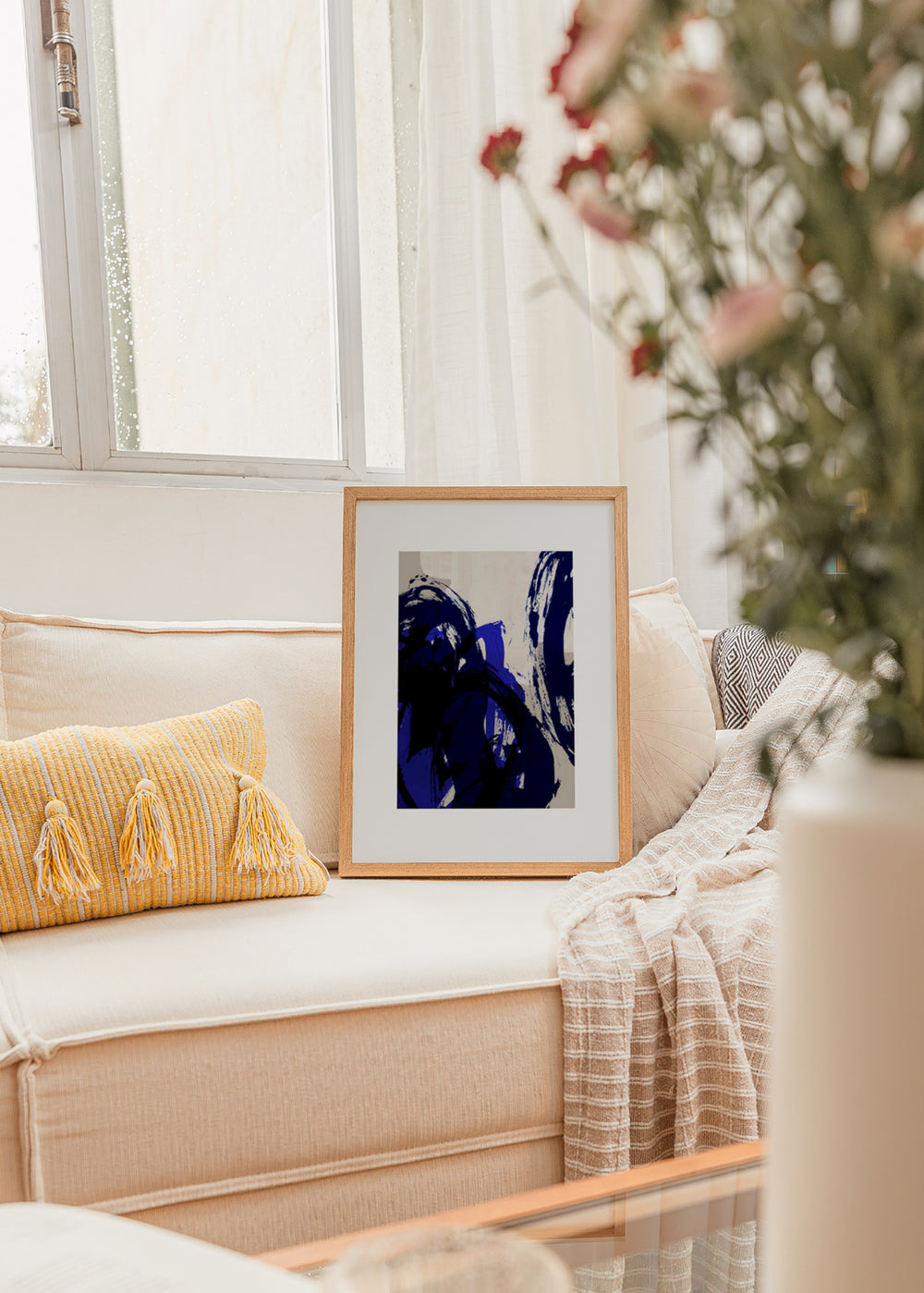 Gerahmtes Wandbild mit abstrakter Komposition aus überlagerten geschwungenen Formen in Elektroblau, Marineblau, Schwarz und hellem Beige, im zeitgenössischen abstrakten Stil. Erhältlich auf kudeko.com