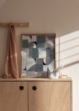 Quadro com composição abstrata de formas geométricas suaves e blocos sobrepostos em cinza azulado, bege, branco pérola, taupe e preto, num estilo abstrato contemporâneo. Disponível em kudeko.com