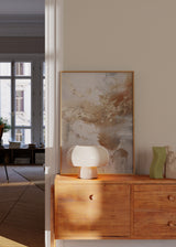 Gerahmtes Wandbild mit abstrakter Komposition aus fließenden Formen in Gold, Beige, Weiß und sanftem Grau auf hellem Hintergrund, im modernen abstrakten Stil. Erhältlich auf kudeko.com