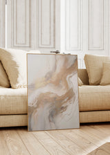 Quadro abstrato emoldurado com composição de formas fluidas em bege, areia, branco sujo, cinzento suave e apontamentos dourados, num estilo abstrato luminoso e depurado. Disponível em kudeko.com