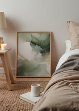Quadro abstrato emoldurado com formas fluidas sobrepostas em verde sálvia, oliva, bege claro e cinzento fumado, estilo leve com contornos esbatidos. Disponível em kudeko.com