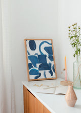 Tableau avec composition abstraite de formes courbes et blocs irréguliers en bleu indigo, bleu pétrole et turquoise sur fond blanc, dans un style abstrait moderne et équilibré. Disponible sur kudeko.com
