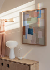 Gerahmtes Wandbild mit abstrakter Komposition aus überlagerten Blöcken in tiefem Blau, Salbeigrün, Altrosa, Beige, Creme und Braun, im klaren zeitgenössischen Stil. Erhältlich auf kudeko.com