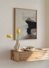 Quadro emoldurado com composição abstrata de formas pretas, cinzento taupe e branco quebrado, contraste suave e estilo contemporâneo depurado. Disponível em kudeko.com