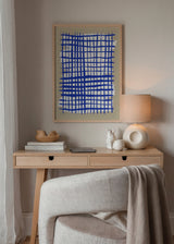 Tableau encadré avec grille irrégulière de lignes bleues, fond blanc centré, beige doux et style géométrique contemporain. Disponible sur kudeko.com